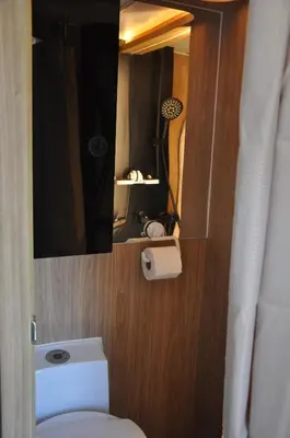 a bathroom with a toilet and a mirror at CoconutRoads Self Drive Motorhome in Phuket