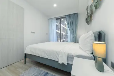 a bedroom with a bed and a window at Premium apartment in Laguna in Thalang
