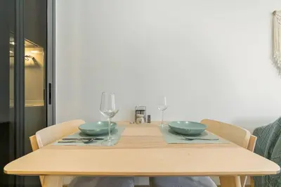 a wooden table with two bowls and wine glasses at Premium apartment in Laguna in Thalang
