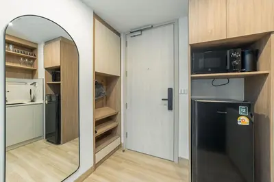 a room with a mirror and a refrigerator in a kitchen at Premium apartment in Laguna in Thalang