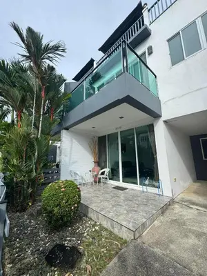 a house with a balcony with two chairs at Kamala Cozy Townhouse in Kamala Beach