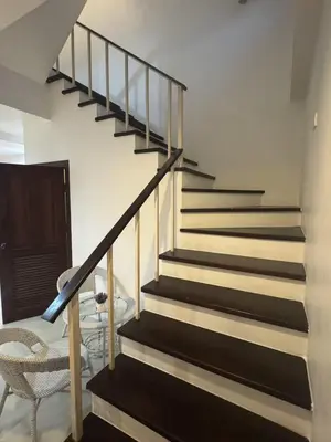 a staircase with black and white stairs and a chair at Kamala Cozy Townhouse in Kamala Beach