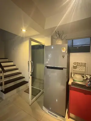 a stainless steel refrigerator in a kitchen with a staircase at Kamala Cozy Townhouse in Kamala Beach