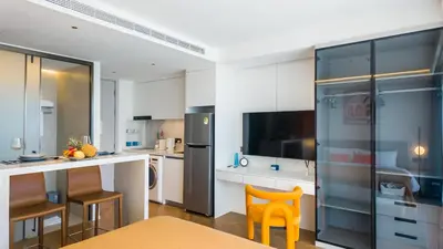 a kitchen with white cabinets and a kitchen with orange chairs at Apartment 50 metres from the sea on Bangtao beach in Layan Beach