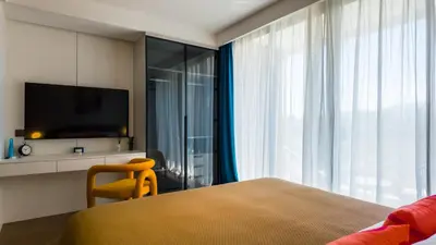 a bedroom with a bed and a tv and a window at Apartment 50 metres from the sea on Bangtao beach in Layan Beach