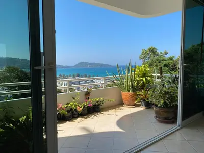 a balcony with potted plants and a view of the water at Andaman hill pool Seaview three bedroom in Patong Beach