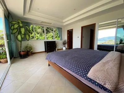 a bedroom with a bed and a large window at Andaman hill pool Seaview three bedroom in Patong Beach