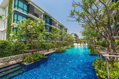 an infinity pool in front of a building at Beach Front Condo on Rawai Beach in Rawai Beach