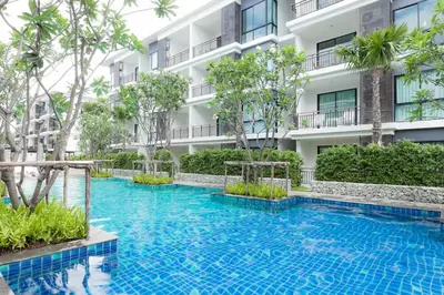 a swimming pool in front of a building at Beach Front Condo on Rawai Beach in Rawai Beach