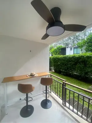 a kitchen with a ceiling fan and two bar stools at Beach Front Condo on Rawai Beach in Rawai Beach
