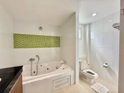 a white bathroom with a tub and a toilet at Bangtao Tropical Residence by Villacarte in Ban Lum Fuang
