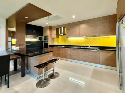 a kitchen with a black counter and yellow at Bangtao Tropical Residence by Villacarte in Ban Lum Fuang