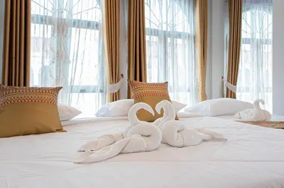 two swans made out of towels on a bed at Baan Sino Phuket in Ban Phlu Yai