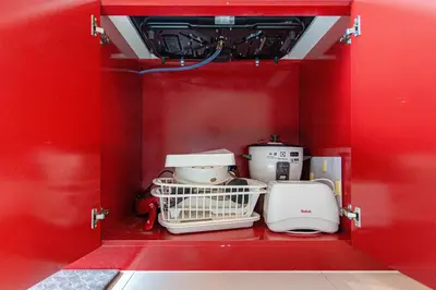 a small red cabinet with appliances in it at Baan Sino Phuket in Ban Phlu Yai