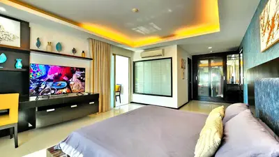 a bedroom with a large bed and a flat screen tv at Phuket KAMALA Apartment in Phuket Town