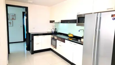 a kitchen with white cabinets and a refrigerator at Phuket KAMALA Apartment in Phuket Town