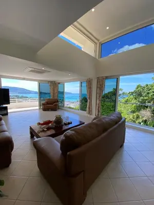a living room with a couch and large windows at Andaman Hills pool Seaview house in Patong Beach