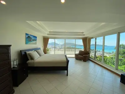 a bedroom with a bed and a large window at Andaman Hills pool Seaview house in Patong Beach