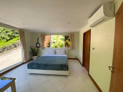 a bedroom with a bed and a large window at Andaman Hills pool Seaview house in Patong Beach