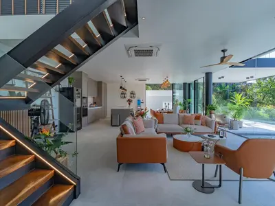an open living room with orange furniture and a staircase at NEW Luxury Seaview 3BR Villa in Layan - Villa Luma in Layan Beach