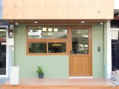a building with a wooden door on the side of it at Bernard Travel in Phuket Town