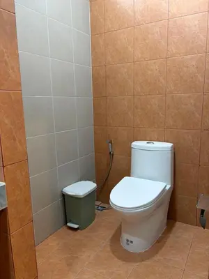a bathroom with a toilet and a trash can at Bernard Travel in Phuket Town