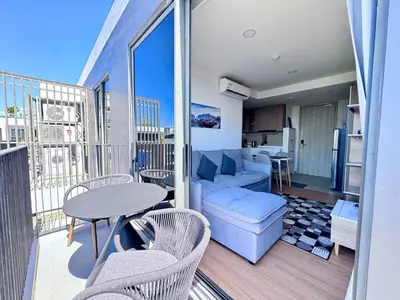 a living room with a couch and a table on a balcony at Laguna Skypark 2 Bedroom scenic view in Laguna Phuket
