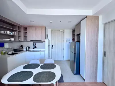 a kitchen with a white table and a refrigerator at Laguna Skypark 2 Bedroom scenic view in Laguna Phuket