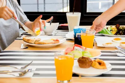 a group of people sitting at a table eating breakfast at Apple A Day Resort Krabi, Ao Nang Beach in Ao Nang Beach