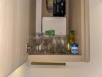 a cupboard with wine glasses and a coffee maker at Great Apartment Sea Heaven 2 min to Nai Thon Beach in Nai Thon Beach