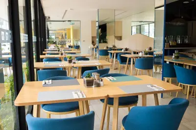 a restaurant with wooden tables and blue chairs at Great Apartment Sea Heaven 2 min to Nai Thon Beach in Nai Thon Beach