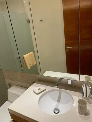 a bathroom with a sink and a mirror and a toilet at Beachfront 2BR Apartment with Pool View in Nai Thon Beach