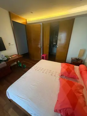 a bedroom with a bed with a red and white comforter at Beachfront 2BR Apartment with Pool View in Nai Thon Beach
