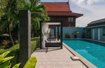 a villa with a swimming pool and a house at Greenleaf Estate - Gated Villas with large shared pool, Nai harn beach in Rawai Beach