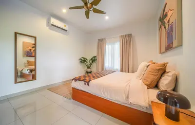 a bedroom with a bed and a ceiling fan at Greenleaf Estate - Gated Villas with large shared pool, Nai harn beach in Rawai Beach