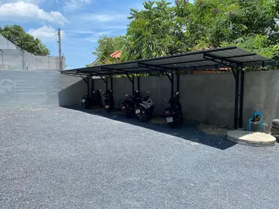 a group of motorcycles parked under a garage at Guest Room Bang Tao MMA in Ban Thalat Choeng Thale