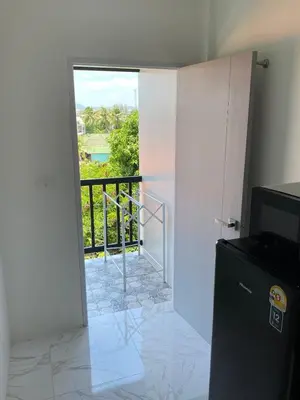 a room with a door leading to a balcony at Guest Room Bang Tao MMA in Ban Thalat Choeng Thale