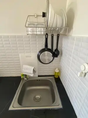a kitchen sink with utensils on a wall at Guest Room Bang Tao MMA in Ban Thalat Choeng Thale