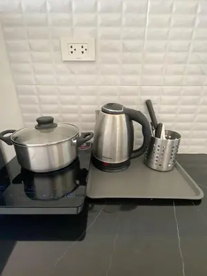 two pots and pans sitting on top of a stove at Guest Room Bang Tao MMA in Ban Thalat Choeng Thale