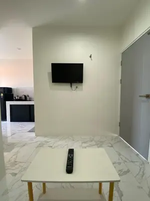 a remote control sitting on a table in a living room at Guest Room Bang Tao MMA in Ban Thalat Choeng Thale