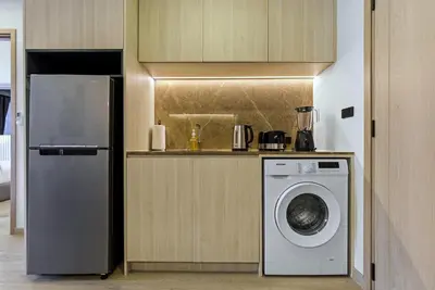 a kitchen with a refrigerator and a washing machine at The Ozone Bangtao by Beringela in Laguna Phuket