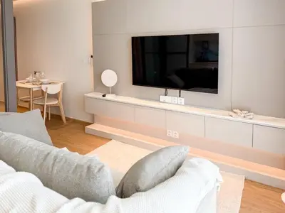 a living room with a tv on a wall at The AQUA A202 in Bang Tao Beach