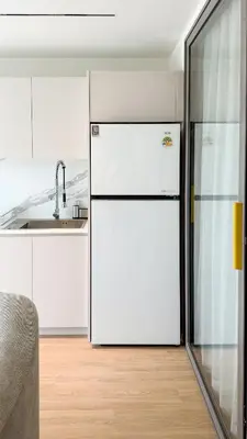 a kitchen with a white refrigerator and a sink at The AQUA A202 in Bang Tao Beach