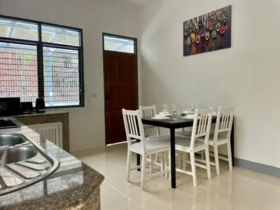 a dining room with a table and white chairs at Private single house Kata Beach in Kata Beach