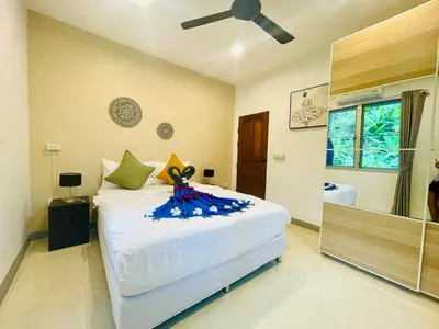 a bedroom with a large bed with a ceiling fan at Private single house Kata Beach in Kata Beach