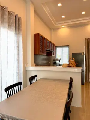 a dining room with a table and a kitchen at Cozy Thai-Style House with Private Pool, Bang Tao in Ban Pak Lak