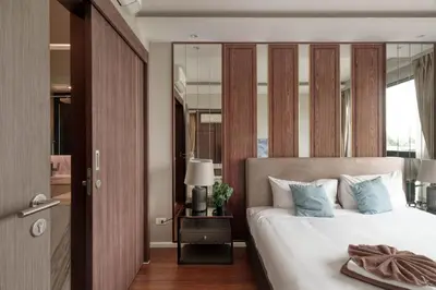 a bedroom with a large bed and a mirror at Ocean Horizon Residences - 2-BR, BangTao Beach in Ban Lum Fuang