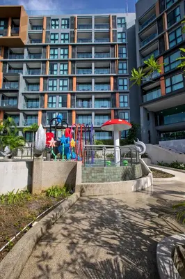 a playground in front of a tall building at Ocean Horizon Residences - 2-BR, BangTao Beach in Ban Lum Fuang