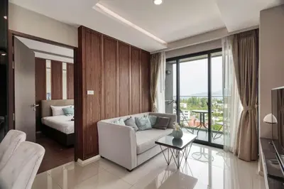 a living room with a couch and a bed at Ocean Horizon Residences - 2-BR, BangTao Beach in Ban Lum Fuang