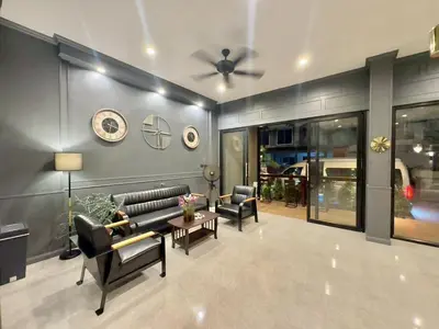 a living room with a couch and chairs and a ceiling fan at The Sense 2 in Patong Beach